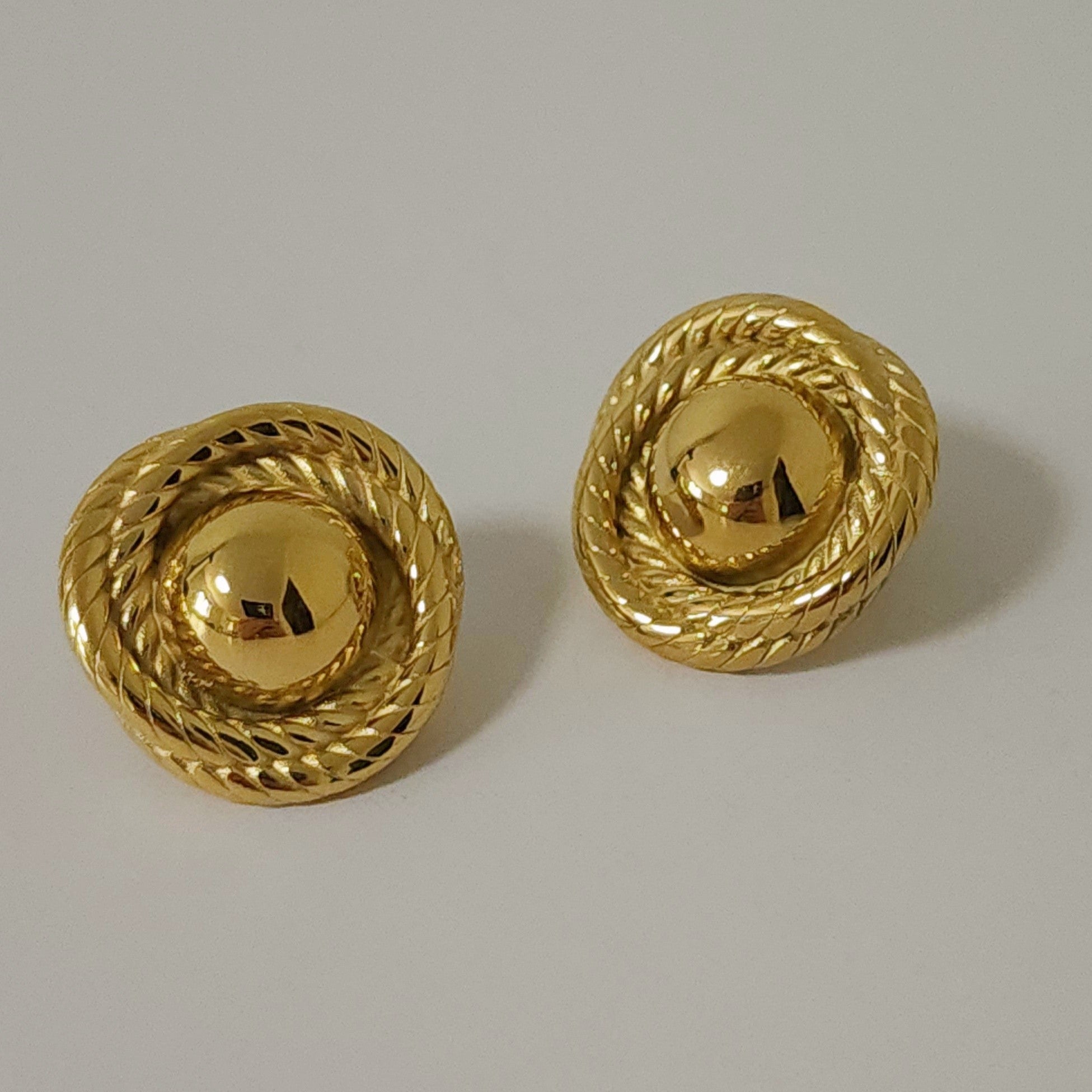 Close up detail shot of gold vintage-inspired statement earrings.