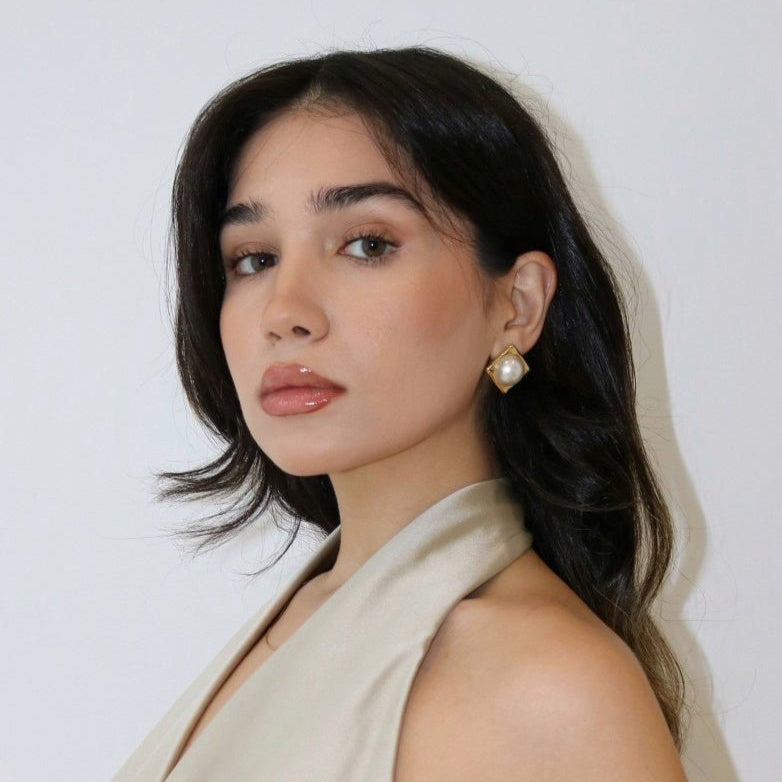 Woman wearing Celeste Pearl Statement Earring in a beige silk halter top