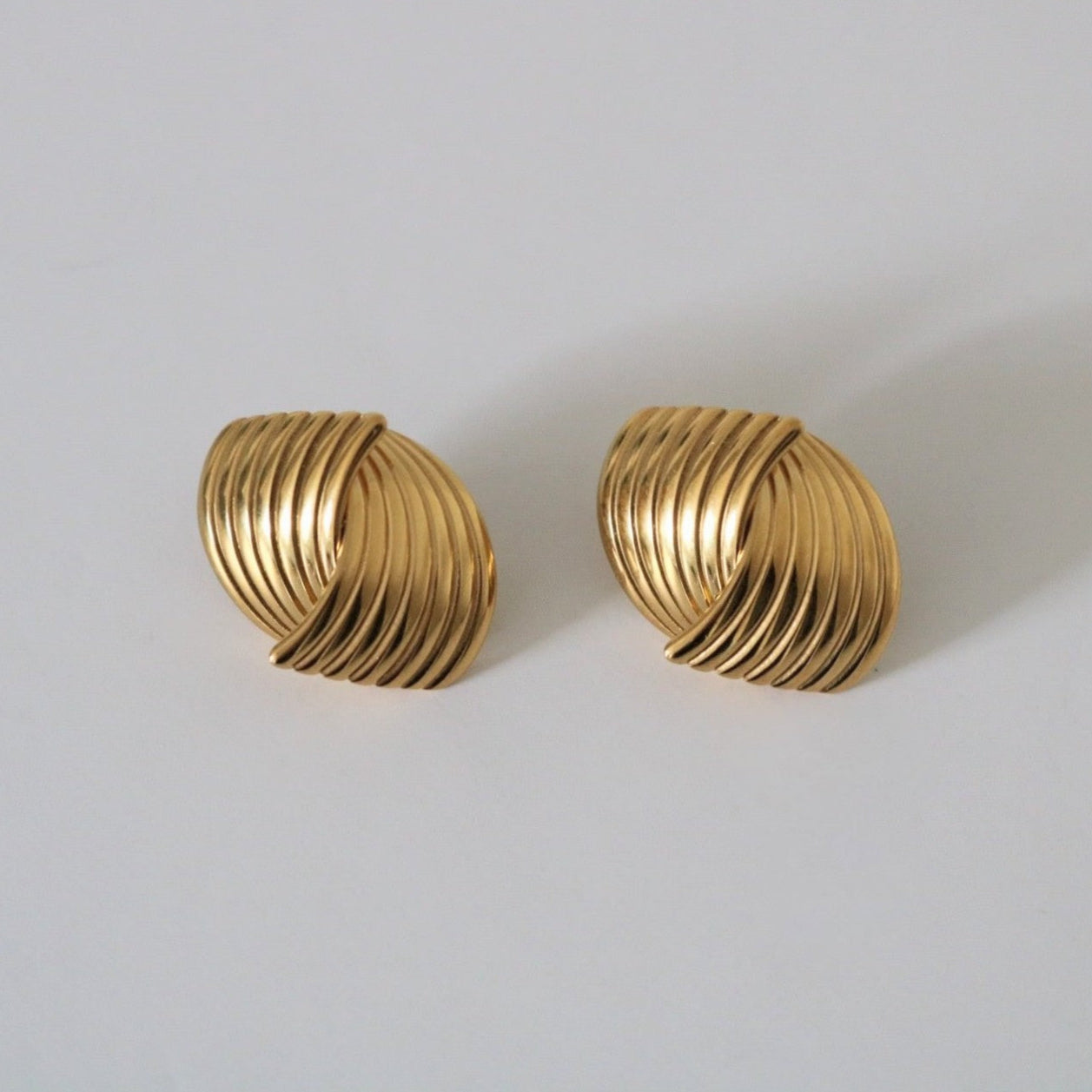 Pair of gold earrings on a light gray background