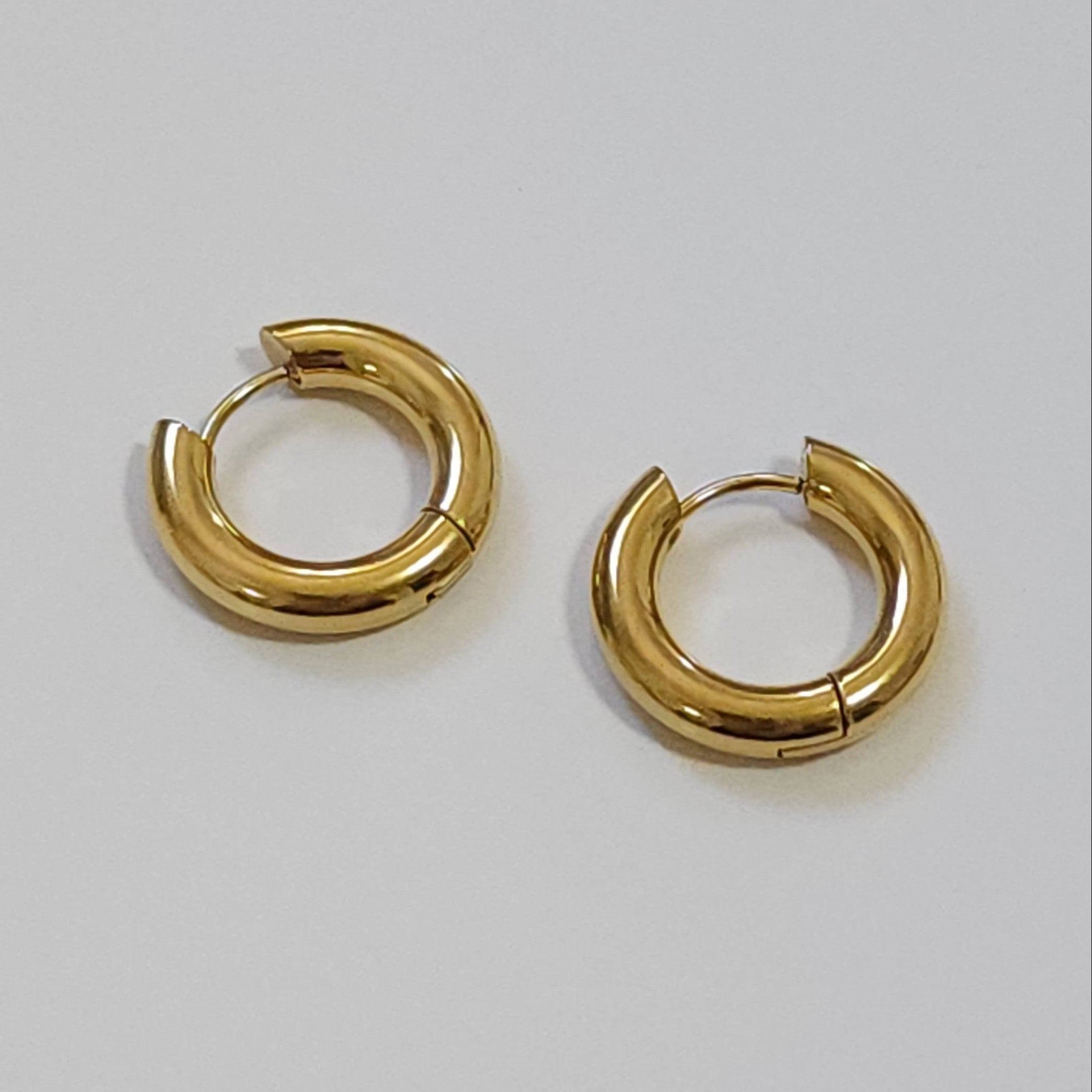 Pair of gold hoop earrings on a light gray background