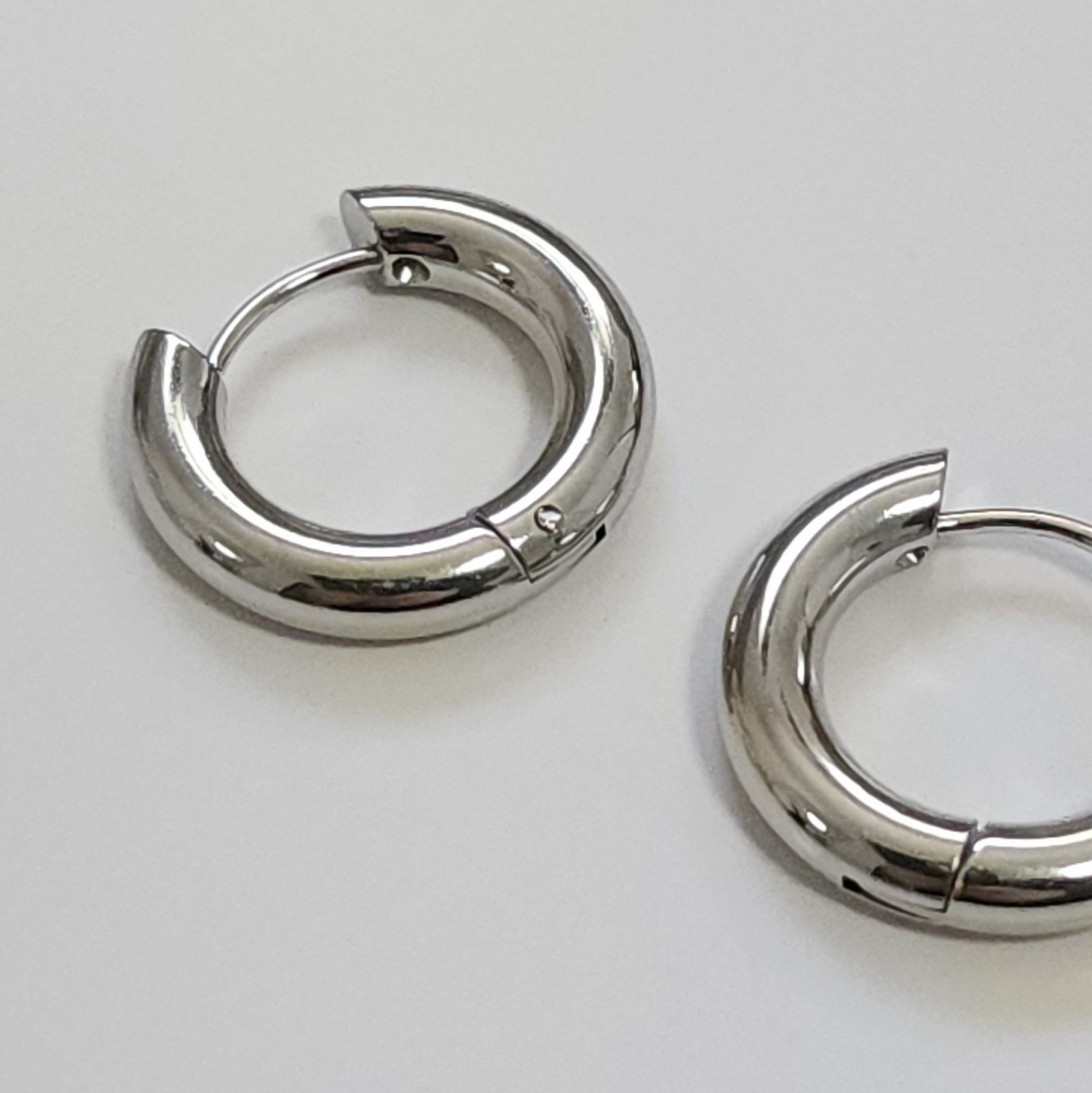 Pair of silver hoop earrings on a light gray background