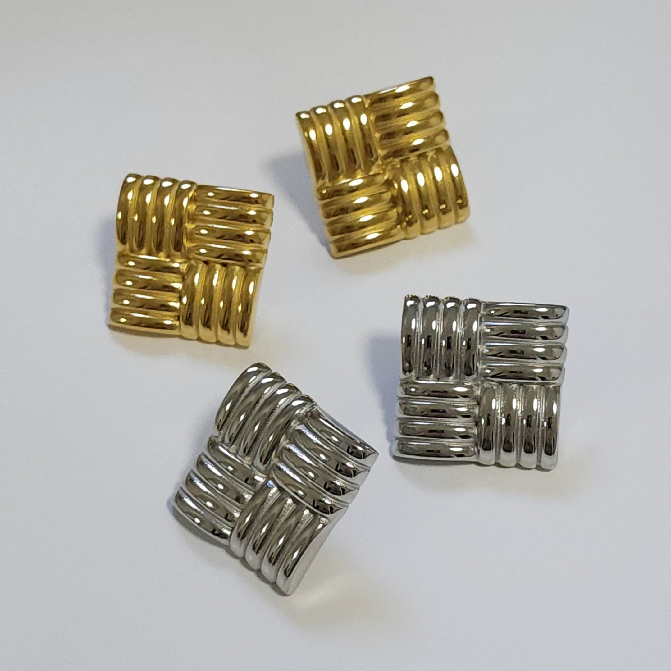 Two pairs of square statement earrings on a white background.