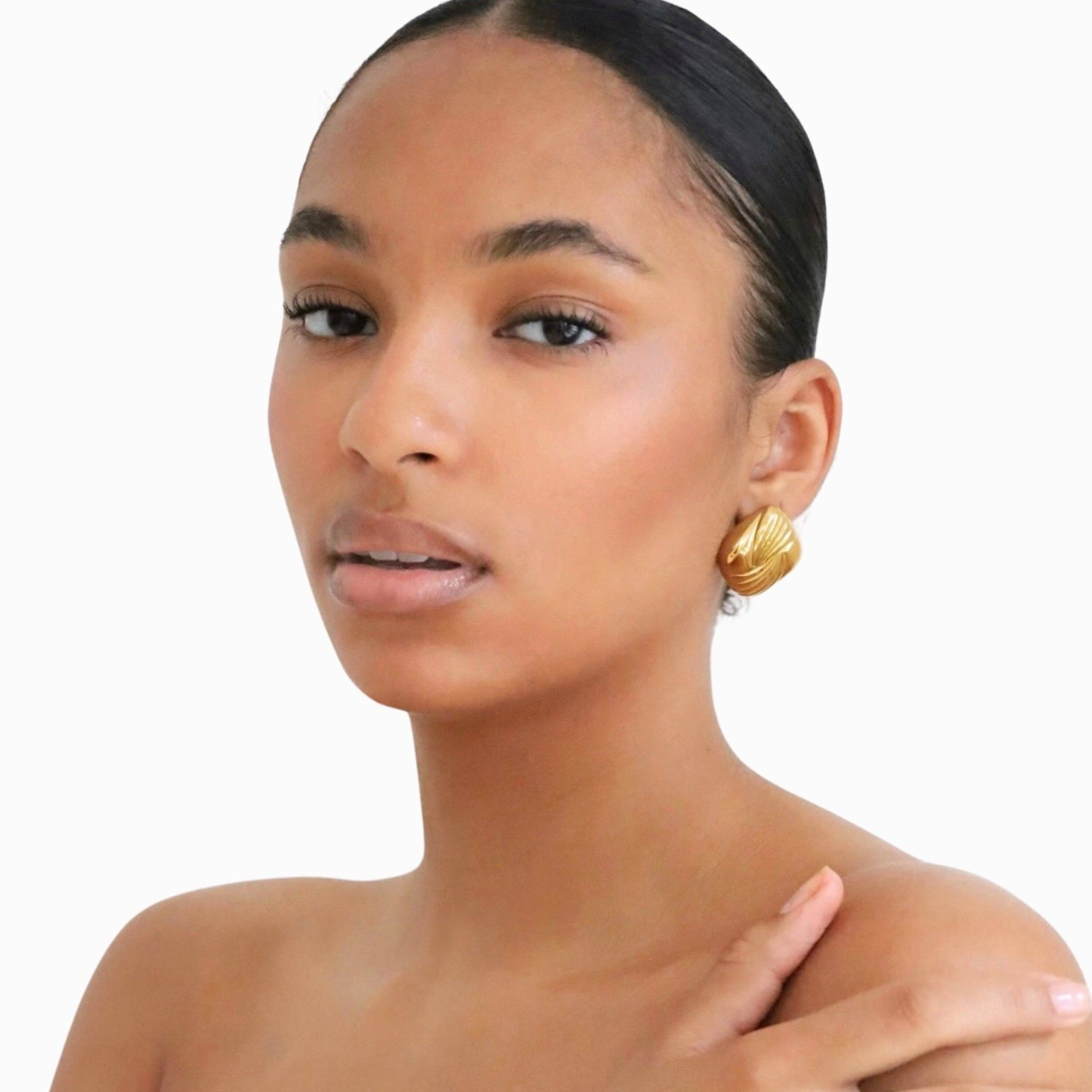 Woman wearing a pair of gold square vintage-inspired statement earrings.