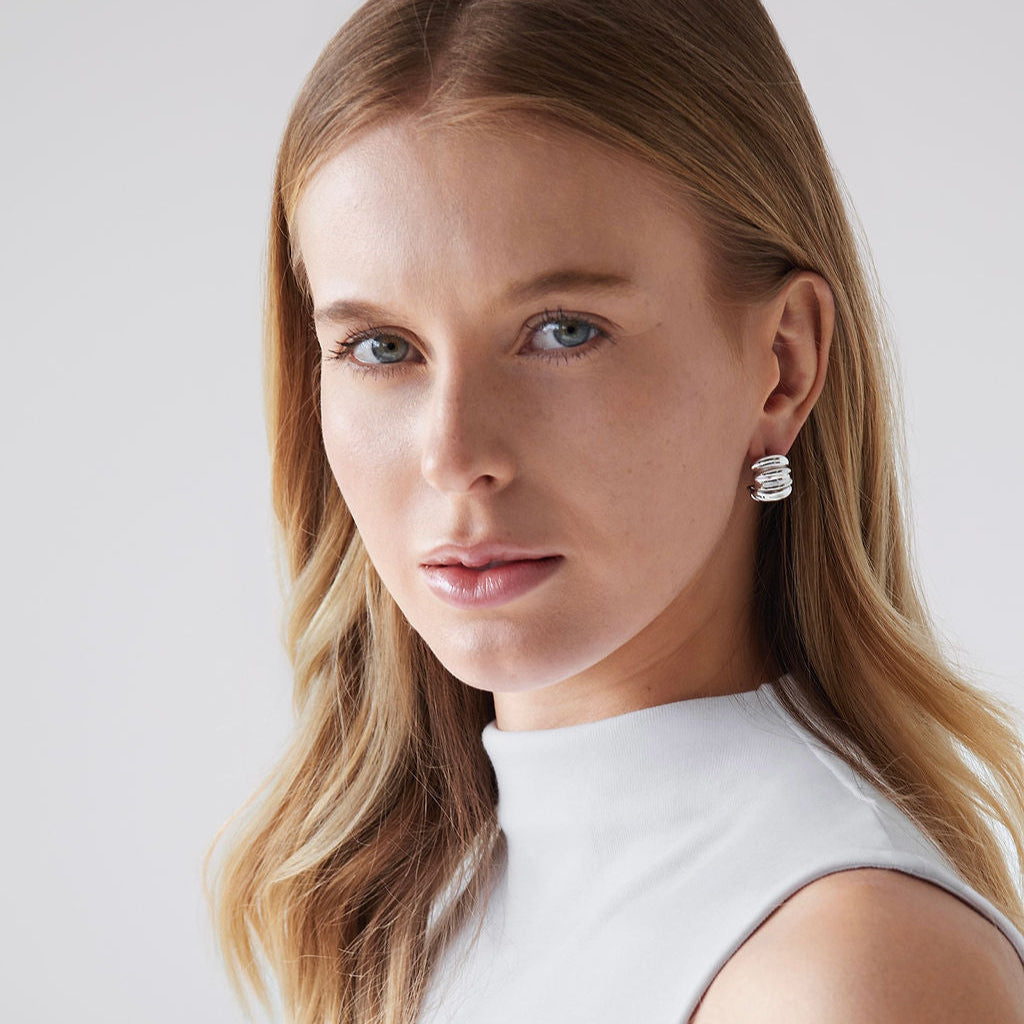Woman wearing Gabriel Abstract Hoop Earrings in silver with a white tank top