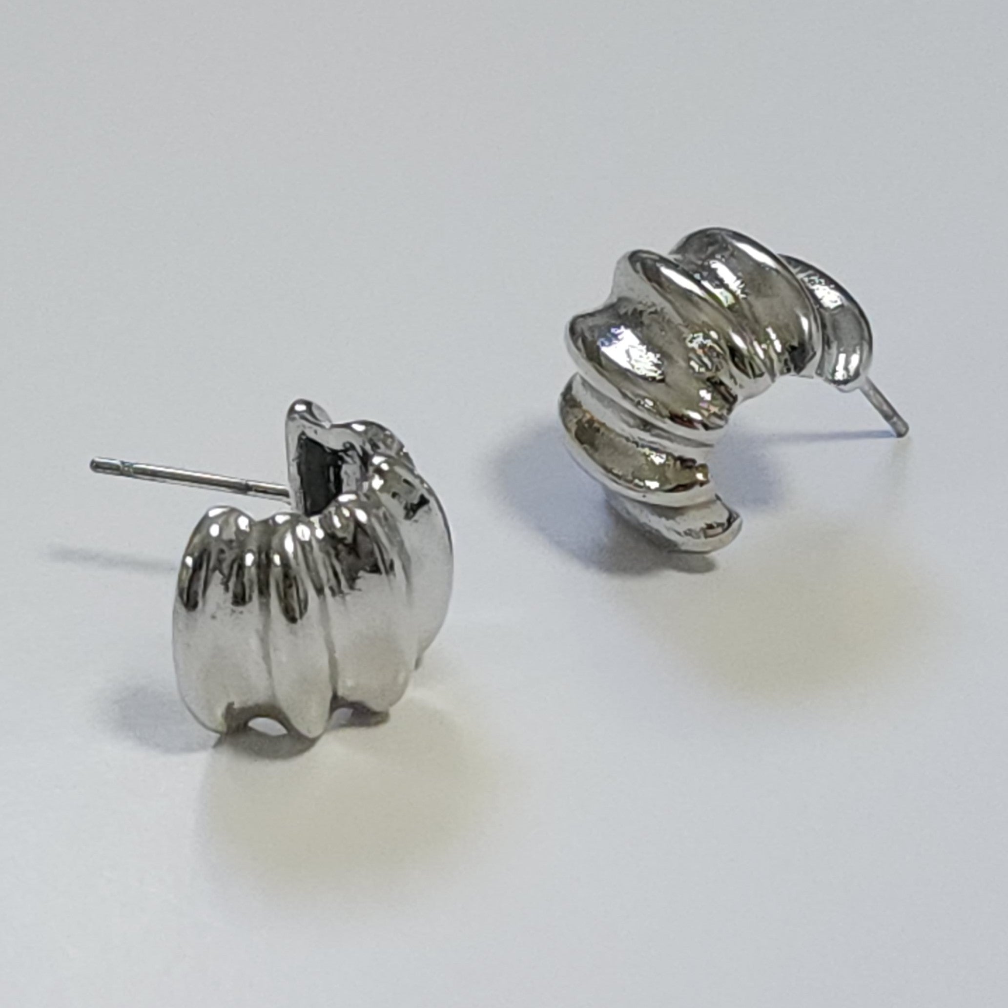 Pair of silver hoop earrings on a light gray background