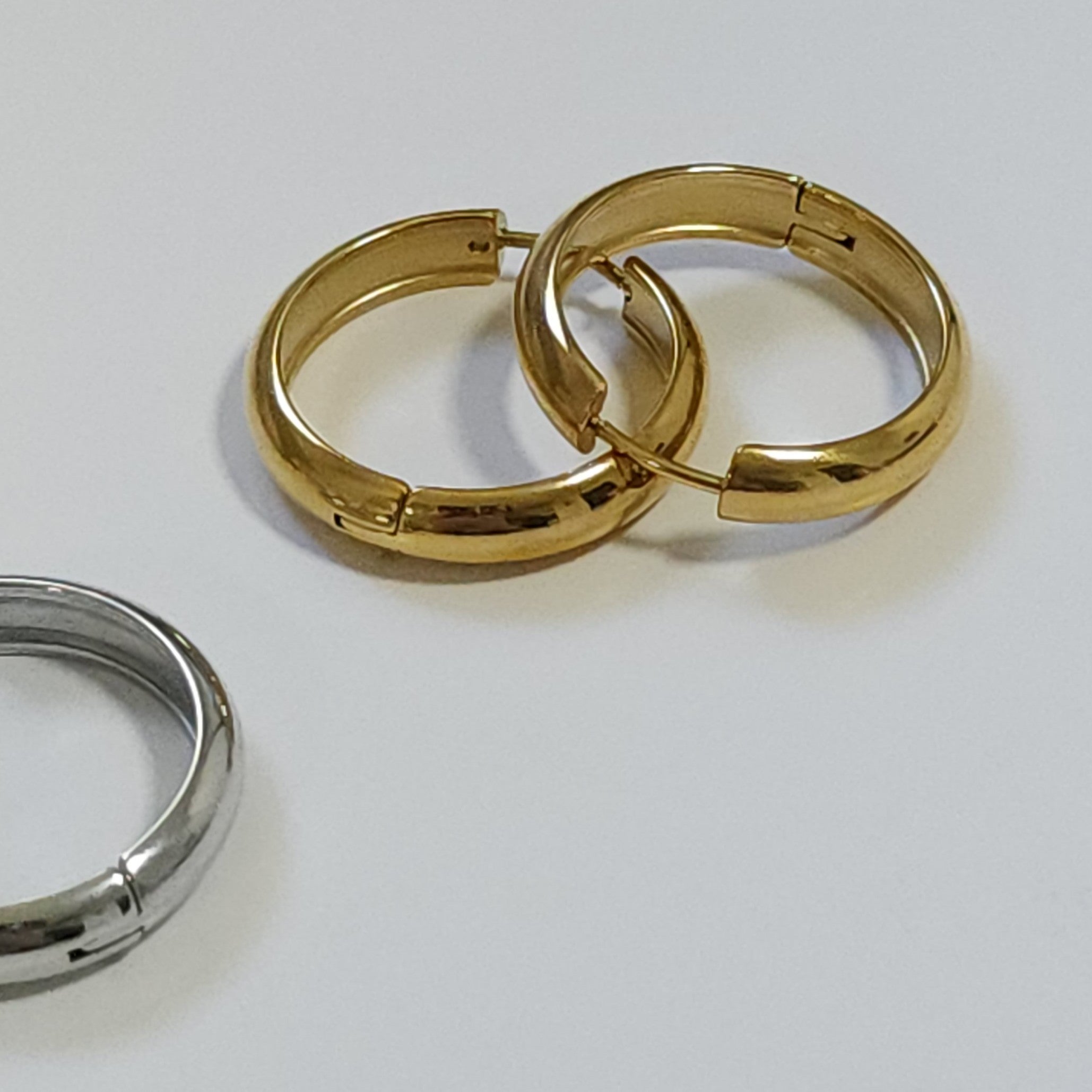 Gold and silver hoop earrings on a white background