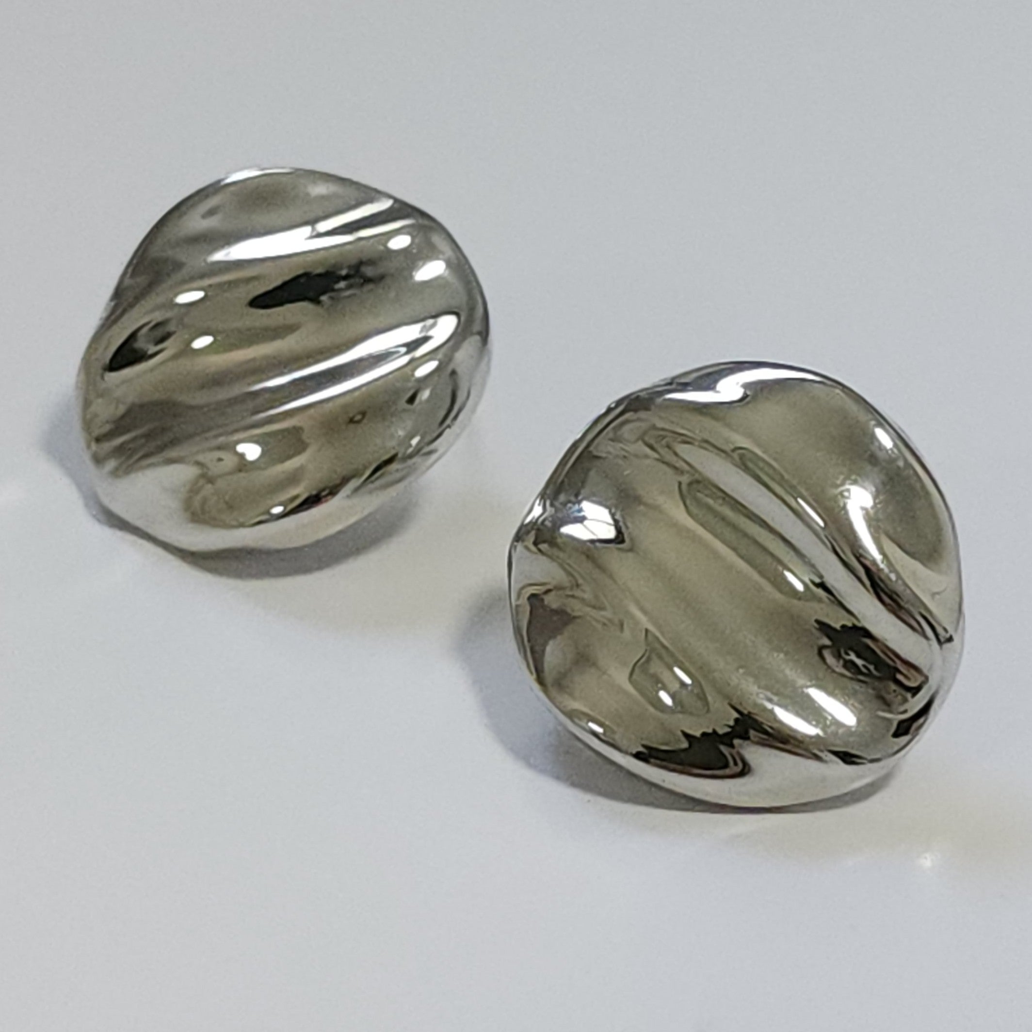 Pair of silver earrings on a light gray background