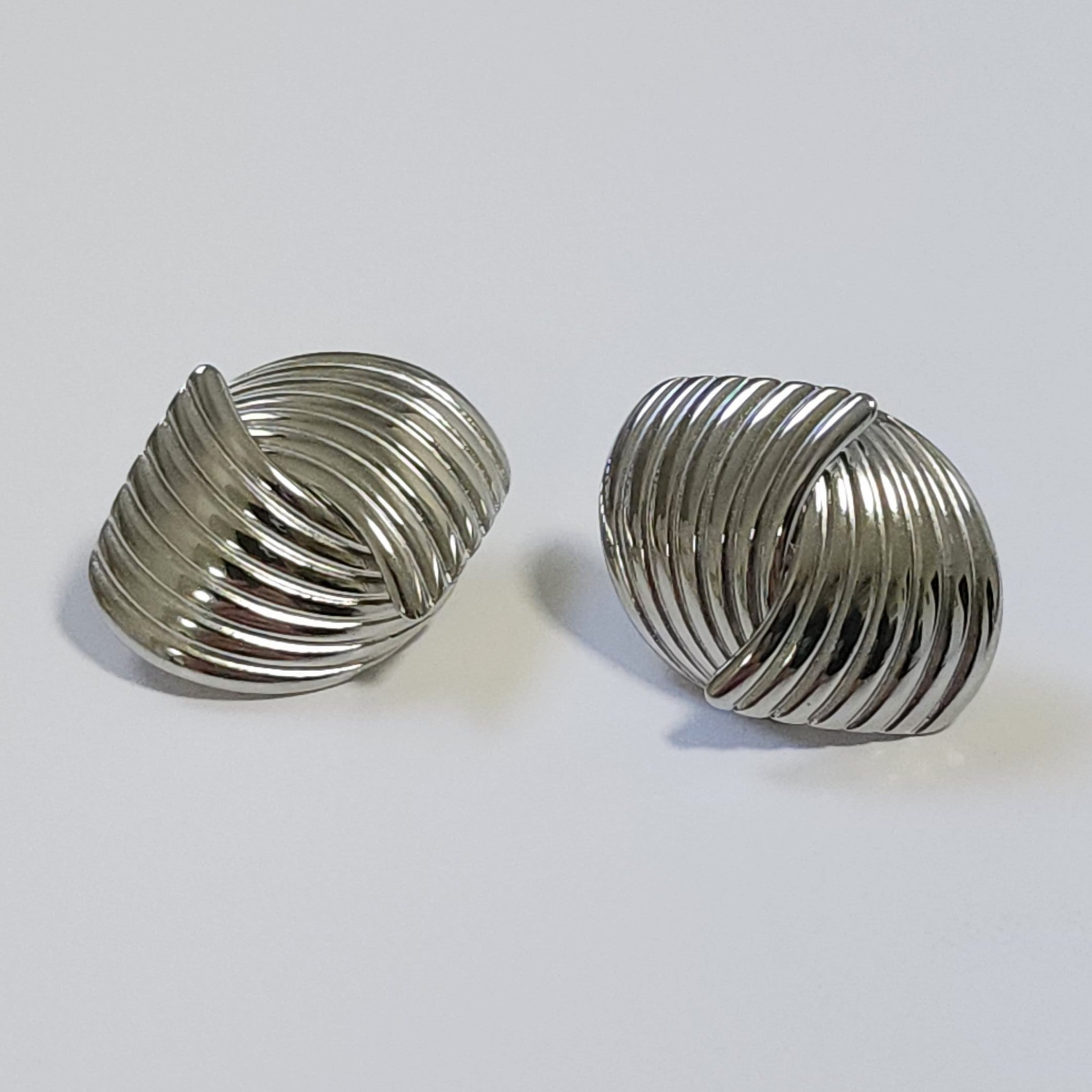 Pair of silver vintage stud earrings on a light background.