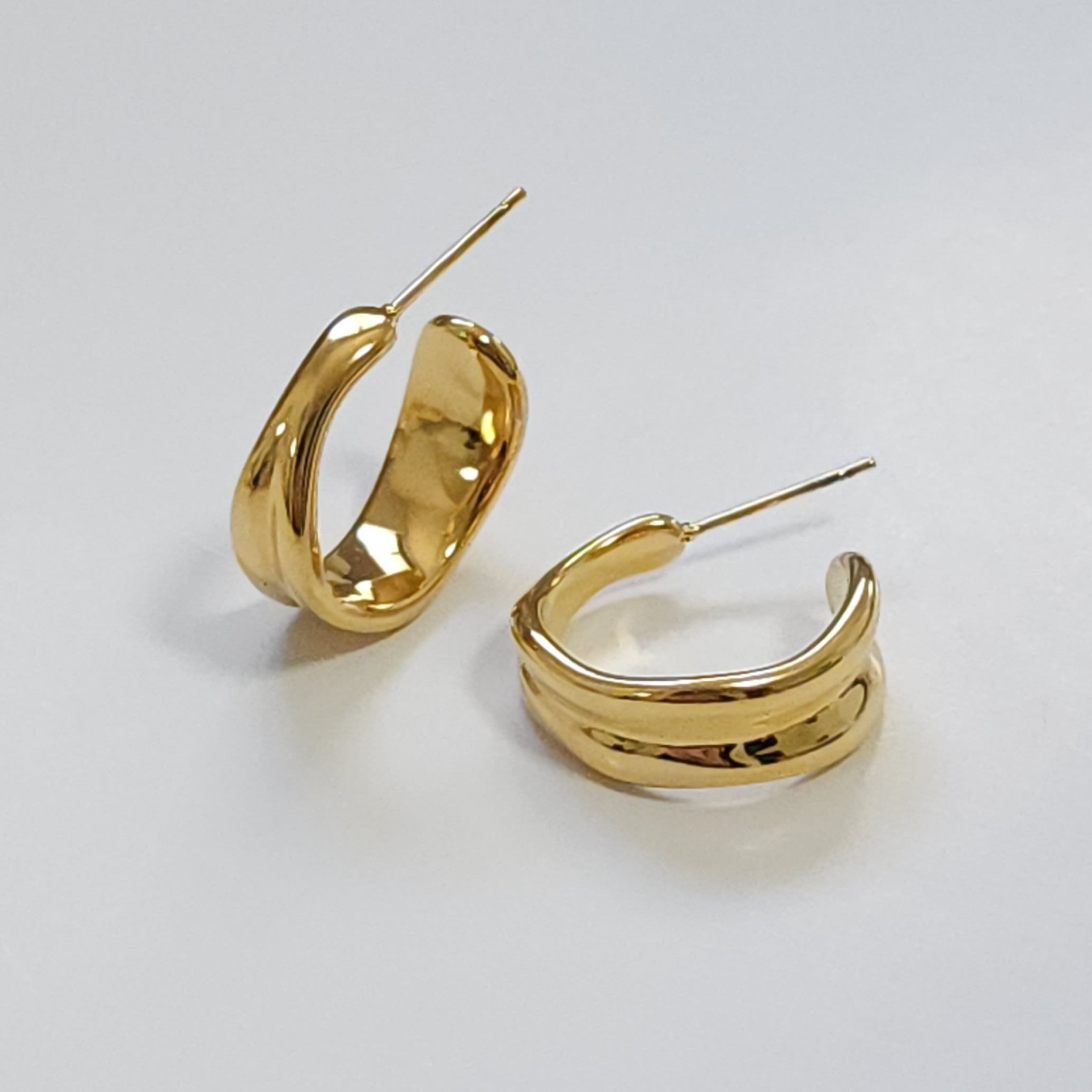 Gold hoop earrings on a light gray background