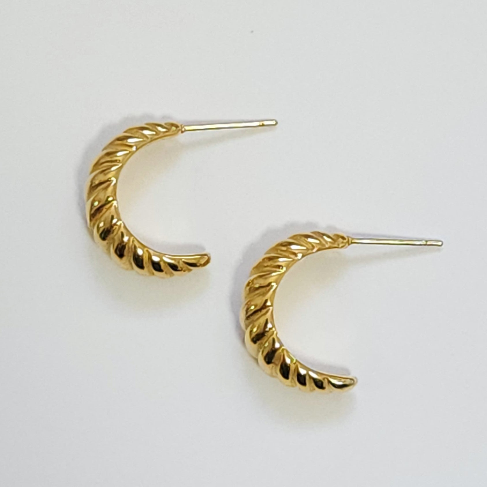 Gold hoop earrings on a light gray background